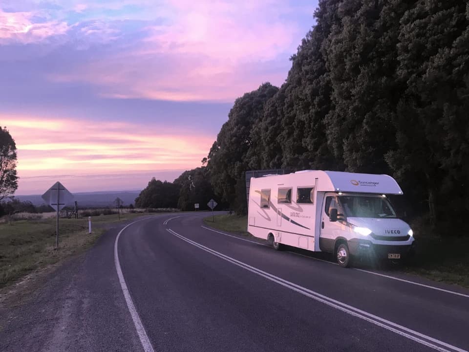 Suncamper Santa Cruz motorhome parked at the roadside under a sunset sky